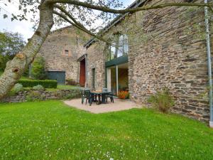 胡法利茲的住宿－Comfortable Cottage in Neufmoulin with Meadow View，一座石头建筑,在院子里配有桌椅