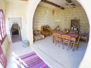 ein Zimmer mit einem Tisch und Stühlen in einem Haus in der Unterkunft Shanti Ghar Gozo in San Lawrenz