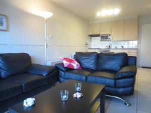 a living room with a couch and a table at Stylish Apartment in Bredene with Pool in Bredene