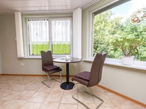 Gernrode - HarzにあるSnug Holiday Home in Quedlinburg near Forestのテーブルと椅子2脚、窓が備わる客室です。