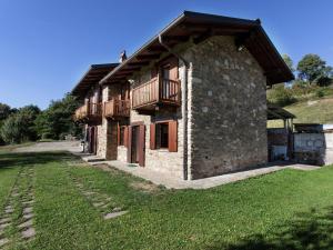 una casa de piedra con un balcón en un lateral. en Belvilla by OYO Cascina Paola, en Netro