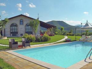 a swimming pool in front of a house at Holiday home in Cagli with swimming pool and fenced garden in Acqualagna