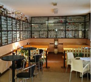 MonzunoにあるR&B Ostello Degli Deiのテーブルと椅子、ワインのボトル棚が備わるレストラン