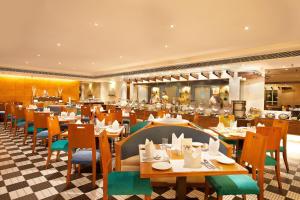 una sala da pranzo con tavoli e sedie in un ristorante di Welcomhotel by ITC Hotels, Alkapuri, Vadodara a Vadodara