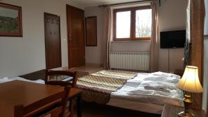 una camera da letto con un letto, un tavolo e una finestra di Willa Dzika Róża a Sandomierz