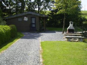 GouvyにあるSplendid Chalet in Gouvy with Fenced Gardenの砂利道の隣の鐘付きの小さな建物