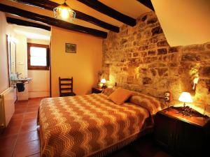 a bedroom with a stone wall with a bed at Belvilla by OYO Cal Grapiss in Llacuna