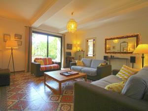 uma sala de estar com sofás, uma mesa e um espelho em Charming holiday home with private pool em Cavaillon