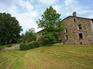 an old stone building with a tree in a field at Quaint Cottage in Egb mont with Garden in Exbomont