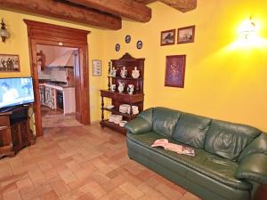 een woonkamer met een groene leren bank en een televisie bij Belvilla by OYO Casa Lella in Serrungarina