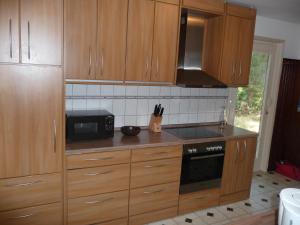una cucina con armadi in legno e forno a microonde di Apartment Holm Seppensen in der Nordheide a Buchholz in der Nordheide