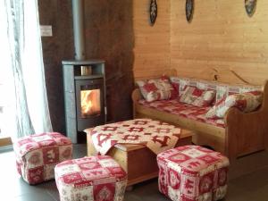 ヴォントロンにあるMagnificent wooden chalet with saunaのベッド2台、オットマン2台、暖炉が備わる部屋