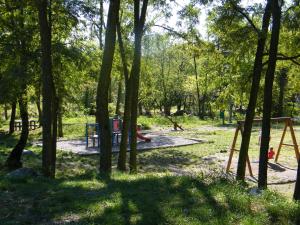 un parc avec une aire de jeux avec des arbres et des balançoires dans l'établissement Cosy holiday home on the river Le Lignon, à La Souche