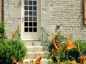 a house with a white door and some flowers at Country cottage with enclosed garden in Bligny in Bligny