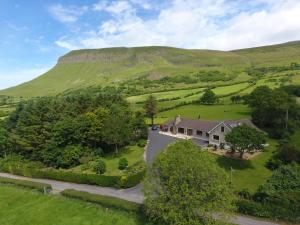 an aerial view of a house in a green field at Benbulben Farmhouse B&B in Drumcliff