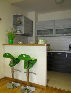 a kitchen with a counter and a green stool at Apartment Verdan in Bar