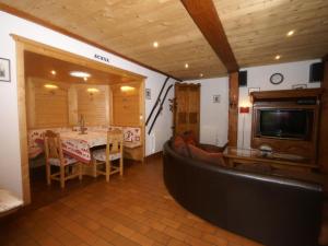 a living room with a table and a couch and a television at Charming Chalet in Ventron with Terrace in Ventron