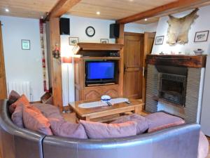 a living room with a couch and a tv at Charming Chalet in Ventron with Terrace in Ventron