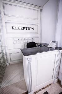 a white room with a reception desk with a phone at City Apartments in Baku