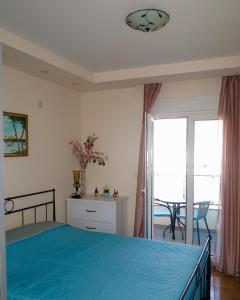 a bedroom with a blue bed and a balcony at Apartment Verdan in Bar