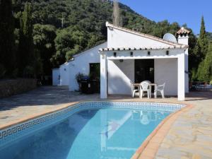 a swimming pool in front of a house with a white building at Belvilla by OYO Las Cerezas in Casares