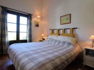 カサーレスにあるBelvilla by OYO Las Cerezasのベッドルーム1室(ストライプ掛け布団、窓付)