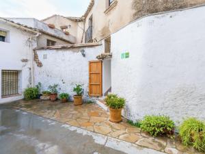 a white building with potted plants and a wooden door at Belvilla by OYO El Rac in Pacs del Penedes