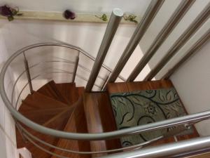 a spiral staircase with a wooden floor and a metal railing at Casa Longo in Castellammare del Golfo