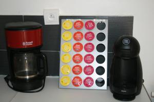 a box of stickers next to a coffee maker and a coffeemaker at Gîte La Lexovienne Lisieux Centre in Lisieux