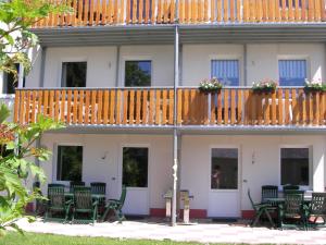 um edifício com uma varanda com cadeiras e uma mesa em Modern holiday home in Burg Reuland with terrace em Burg-Reuland