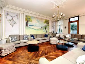 uma sala de estar com sofás e mesas e um lustre em Luxurious Mansion with indoor pool and Sauna em Mesnil-Saint-Blaise