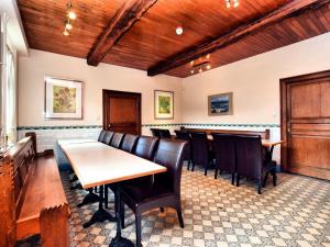 uma sala de jantar com cadeiras e mesas e tectos em madeira em Luxurious Mansion with indoor pool and Sauna em Mesnil-Saint-Blaise