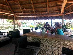 a man and woman sitting at a bar in a restaurant at On The Beach - Lux 2 Bedroom Miami in Hollywood