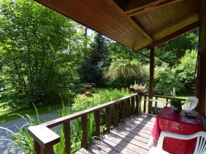 a wooden deck with a table and chairs on it at detached chalet in lovely hiking region in Bellevaux