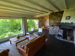 a living room with a couch and a fireplace at Modern Chalet with Private Tennis Court in Humain in Humain