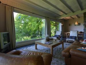 a living room with a couch and a large window at Modern Chalet with Private Tennis Court in Humain in Humain