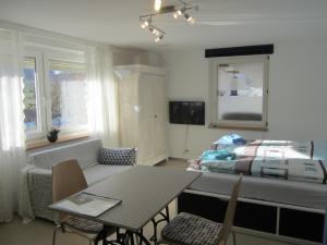 ein Wohnzimmer mit einem Tisch und einem Bett in der Unterkunft BnB Mönthal im Jurapark in Mönthal 