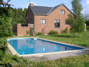 una casa con piscina frente a una casa en Apartment with pool and sauna, en Felenne