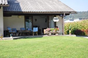 a house with a patio with chairs and a table at Seebungalows Wedenig direkt am See in Krumpendorf am Wörthersee