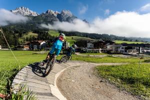 dwoje ludzi jeżdżących rowerami na szlaku w górach w obiekcie Appartementhaus Salzmann w mieście Leogang