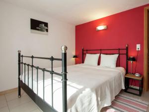 1 dormitorio con 1 cama con pared roja en Cozy Apartment in Stoumont with Private Terrace, en Stoumont