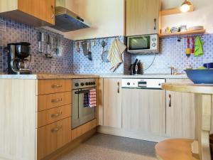 a kitchen with wooden cabinets and a counter top at Apartment in Reitersau near the ski area in Steingaden