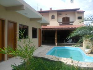 a house with a swimming pool in front of it at Pousada Nossa Casa in Aparecida