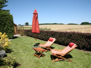 Peaceful Cottage in Ardennes with Private Terrace في باستوني: كرسيين ومظلة في العشب