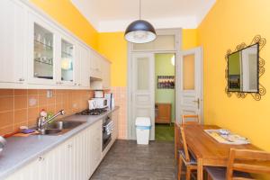 une cuisine avec des murs jaunes et une table en bois dans l'établissement Andrews Centre Apartment, à Prague