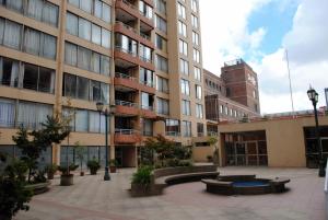 a courtyard in front of a building with a clock tower at EcoApart Concepción in Concepción