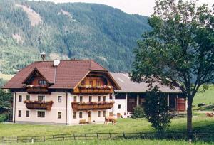 une grande maison blanche au milieu d'un champ dans l'établissement Bauernhof Trinkergut, à Unternberg