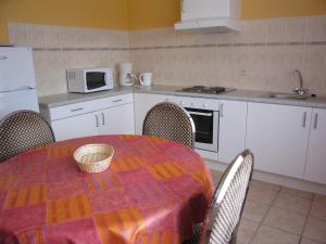 cocina con mesa con sillas y microondas en Spacious Apartment in Ondenval with Terrace, en Waimes