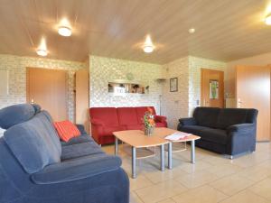 Sala de estar con 2 sofás y mesa en Spacious Apartment in Gr fflingen with Sauna, en Burg-Reuland