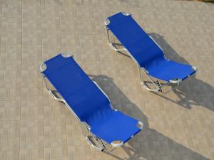 two blue beach chairs sitting on a sidewalk at Beautiful spacious villa near Makry Gialos in Makry Gialos